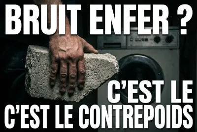 Main tenant un morceau de béton cassé devant un lave-linge bruyant.