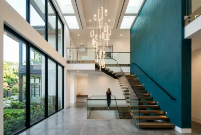 Décoration d'escalier moderne avec luminaire suspendu et mur coloré.