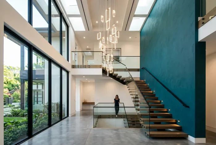 Décoration d'escalier moderne avec luminaire suspendu et mur coloré.